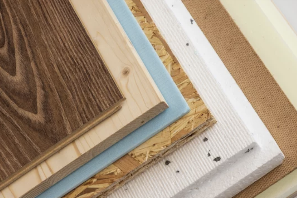 Close-up of various construction materials layered on top of each other, including wood, insulation, and other building materials.